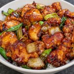 Mongolian Chicken with tender chicken pieces coated in glossy garlic soy sauce and garnished with green onions